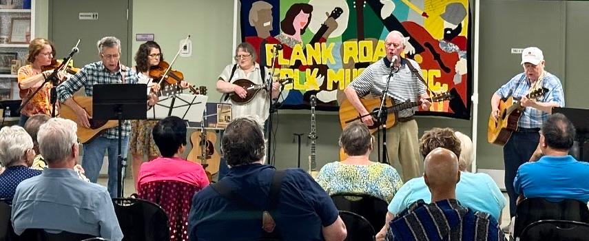 Image of Plank Road performers with the Plank Road Quilt as backdrop